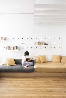 Pegs slot into holes in the white laminate wall to support shelf units.