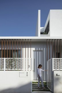 The pattern of the decorative screen for the stairs is repeated on the fence that surrounds the house.