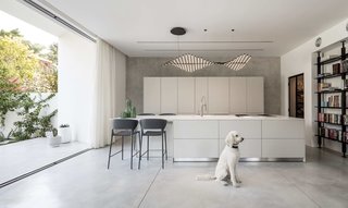 The open interior of white walls and polished concrete floors echoes the restrained aesthetics of the façade.