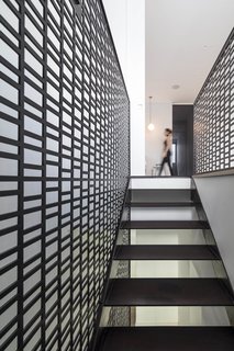 Inside, the vertical lines expressed by the exterior screen are replicated in the staircase that connects the four floors.