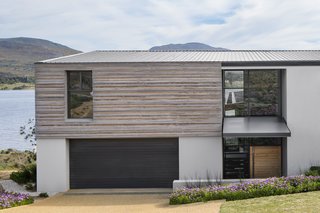 At the back of the property is a deliberately understated entrance, and a simple canopy that shelters the front door. This door opens onto a landing, from which a broad corridor follows the natural gradient alongside a generous garden courtyard. 
