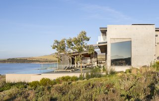 The roofs are made of corrugated aluminum, and the timber sidings used at the entrance are repeated on key ceiling planes.