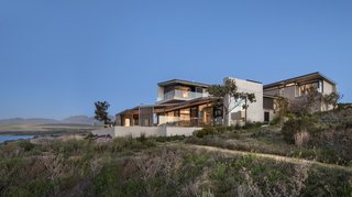 "This distinctive sheltering shape is again expressed in the wrapped floor-wall-roof profile of the three wings, which—assembled together, one above the other—track the site as it slopes toward the water," says Philip Olmesdahl.
