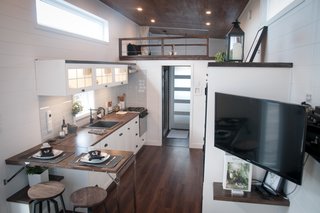 Other features include a modern glass-ceramic kitchen backsplash, a granite sink, textured melamine panels, a hardwood countertop, and wood shelves. 