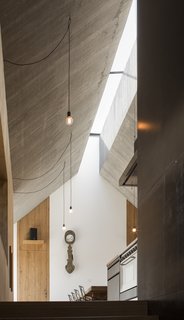"The ridge of the roof is pushed apart, creating a continuous skylight that runs throughout the house’s linear volume and provides top light for all the crucial spaces," says Dekleva. 