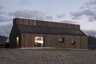 Square-shaped windows frame views of the quiet village and beyond.