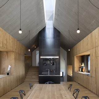 Within, oiled oak is used for the floors and walls, while the roof is composed of reinforced concrete that reveals the imprint of the wooden formwork.