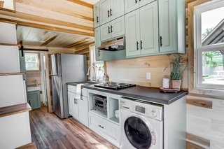 The kitchen includes a four-burner stovetop, convection oven, fridge/freezer, washer/dryer, sink, breakfast bar, and custom cabinetry.