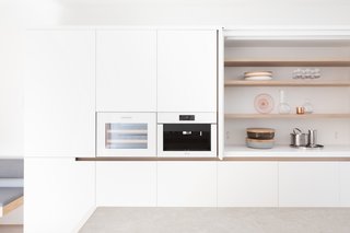 In the kitchen, white lacquer millwork is complemented by white glass.