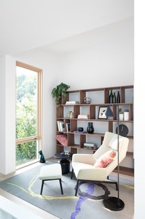 A Bensen chair and shelves, along with a Diurne carpet from Salari, sit in the den.