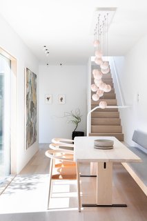 A Bocci 84.21 pendant, Bensen chairs, and Delta art lighting can be found in the dining room.