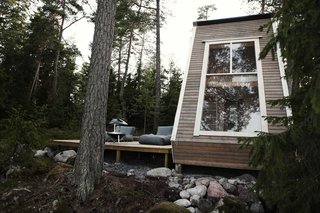 Adjacent to the cabin is a spacious deck that is raised above the ground on wooden stilts.
