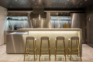 Due to its location under a lower ceiling, the kitchen gets the least amount of natural light in the home. However, the architects have mitigated this problem by using stainless steel surfaces, which reflects sunlight streaming in through the dining and living.