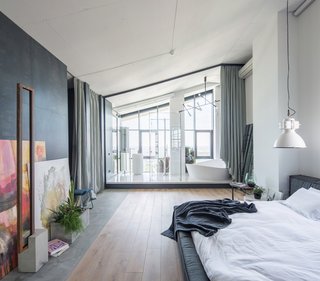 The open, airy atmosphere continues in the bedroom where the ensuite is fitted with a glass wall. 
