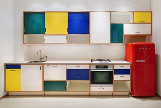 The kitchen was relocated from the back of the space to the center. Here, Corian has been used for the countertops, backsplash, and sills.