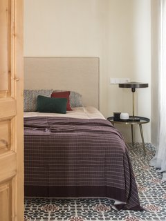 Patterned hydraulic tiles on the bedroom floor.