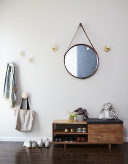 Wood hooks are by Muuto; leather-wrapped mirror by Jamie Young Company; entry bench by Mash Studios; and wall sconces by Park Studio LA. 