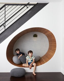 The space below the stairs was turned into a cheerful play area for the two boys. "We built an egg shaped 'nook' underneath the staircase, and filled it with soft ‘pebble’ pillows," adds Tang.