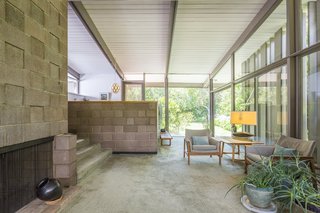 Simple geometric volumes are constructed with glass walls that connect the interiors to the outdoors. 