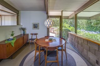 Arranged along a central spine, the Grant House has an open floor plan, a family room, and a kitchen and dining area that merges with a step-down living space.