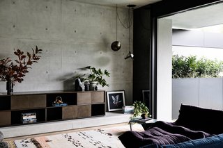 Wood floors and carpet provide a warm contrast to the cool concrete walls.