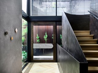 Upon entering the abode, a sculptural, folded-plate staircase immediately catches the eye.