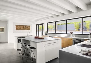 The spacious kitchen has smart, built-in storage and serving-windows set at countertop-height, which open out onto the pool terrace and entertaining area. 