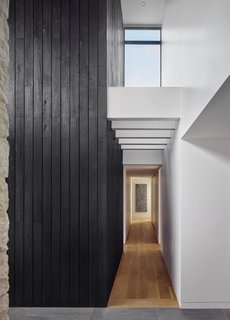 Shou-sugi-ban sections of the facade wraps in to the interior to become accent walls.