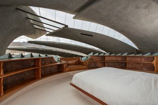 The circular master bedroom is supported by an illuminated, mushroom-shaped structure.