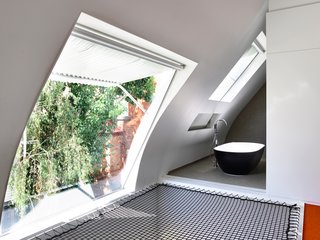 "The parents can now step out of the bath, slide the wall away, and then air dry themselves on the net in front of the big, sunny, north-facing window," says Maynard. 