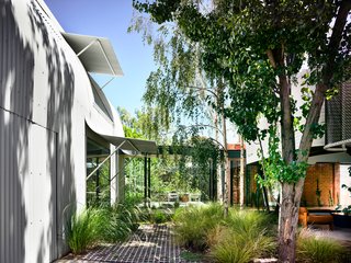 The main house, rear stable, and a new pavilion in the garden were unified with corrugated, ColorBond steel metal cladding. 