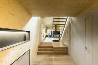 A hallway leads up to the open-plan living, dining, and kitchen areas.