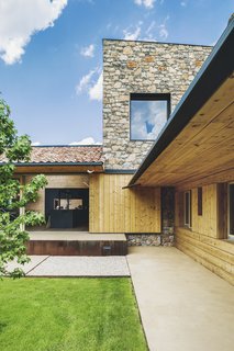 "The stone wall slightly protrudes above the roofs and highlights the simple forms guided by the plot’s shape," says Elorduy. "The wall draws a series of slopes and counter slopes providing the house with a singular geometry." 