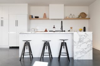 A continuous open-plan living, kitchen, and dining area with a powder room is located in the living level. 