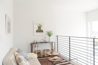 The generous, double-height entrance lounge is equipped with washer/dryer utilities tucked under the stair with a cantilevered mezzanine "book nook" right above it. 