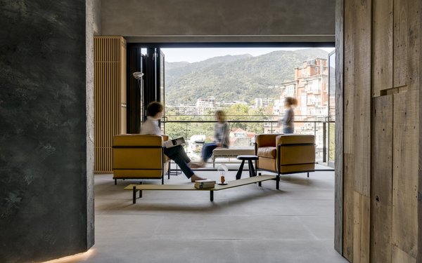 Balconies and generous windows visually connect the interiors to nature outdoors.