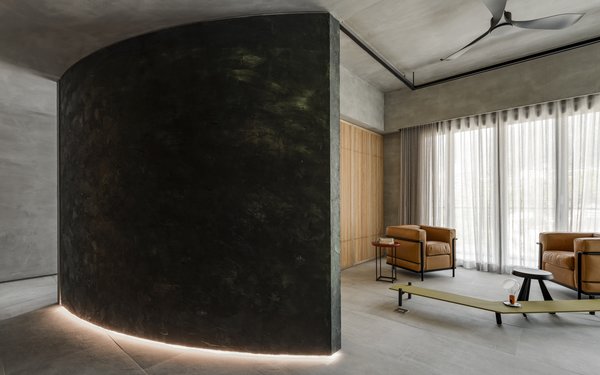The lower convex edge of the structure is fitted with strip lighting, which when switched on, illuminates the passageway between the curved structure and the interior wall.