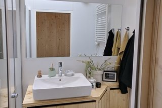 The bright bathroom is fitted with skylight windows, and is equipped with Grohe fixtures and a walk-in rain shower. 