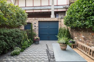 The dark blue, street-side door leads into the garden.