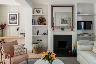 In the reception room is a lounge area with a gas fire at one end, and a study space with a built-in desk and shelves. 