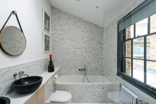 Next to the kitchen is a discreet toilet, and next to that, a door that leads down to a basement that was converted into a utility area with a worktop and Corian sink.