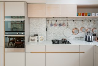 Marble and mosaic tiles are used for the simple, minimalistic kitchen, which includes a larder cupboard. 