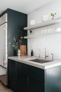 A peek at the dark green, fuss-free kitchen.