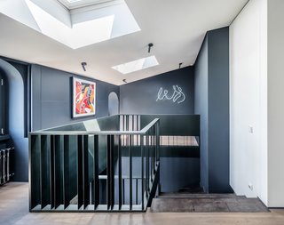 Though devoid of period ornamentation, the attic loft follows the same monochromatic palette and feels like a natural extension of the ground floor.