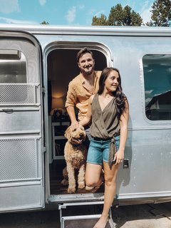Augustine the Airstream's original interiors included a bedroom with two classic twin beds and a dresser between them, a living lounge, kitchen, dining booth, and bathroom. The nearly 30-year-old exterior had an uneven, weathered appearance, so the Lavenders used two rounds of paint stripper before being able to buff and polish it.