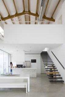 Floating stairs in the dining area lead up to a mezzanine loft.