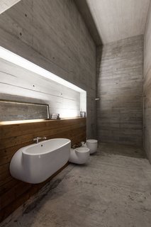An industrial-inspired bathroom has fixtures that look like sections of cut pipes.