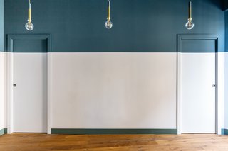 Large sections of this wall are painted bright blue and gray-green, but the architects were careful not to allow the bold colors to overwhelm the space. 