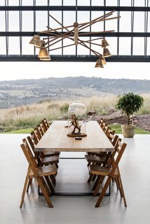 In warm summer months, the automated glass façade opens up the conservatory, creating an outside patio that draws and circulates natural breezes throughout the house.