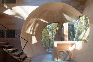 The geometry of the spherical intersections becomes apparent at the entry porch, where an orb of wood welcomes visitors.